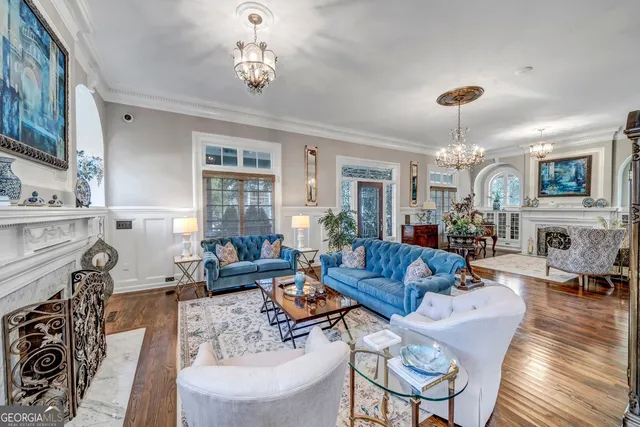 a living room with lots of furniture hardwood floor and a large window