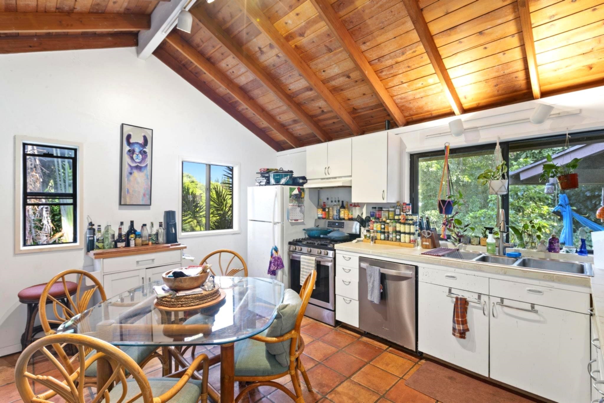 105 East Kuiaha Road Haiku, HI 96708 - Photo 5 of 24 a kitchen with stainless steel appliances granite countertop a stove a sink dishwasher and cabinets with wooden floor