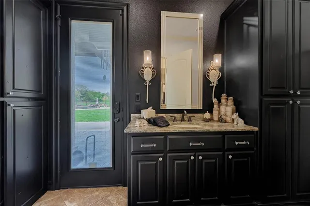 a bathroom with a granite countertop sink and a mirror