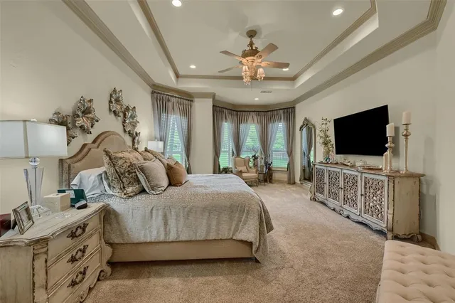 a bedroom with a bed and a flat tv screen on dresser