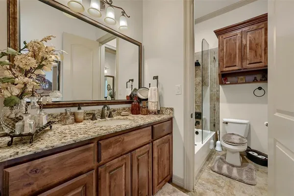 a open kitchen with stainless steel appliances granite countertop a sink dishwasher a stove a dining table and chairs with wooden floor