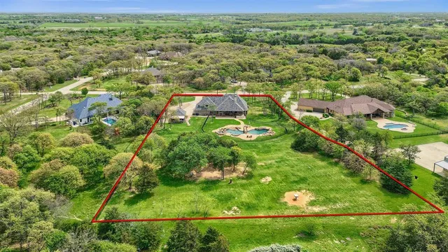 an aerial view of residential houses with outdoor space and trees