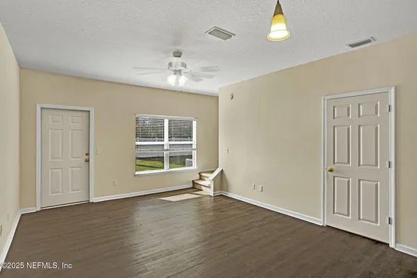 an empty room with wooden floor and windows