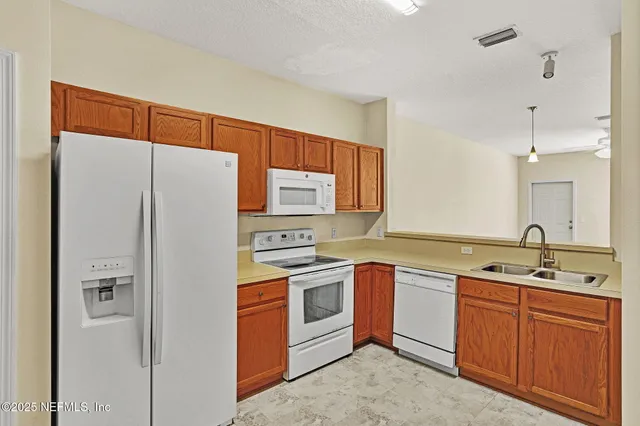 a kitchen with a sink a refrigerator and cabinets