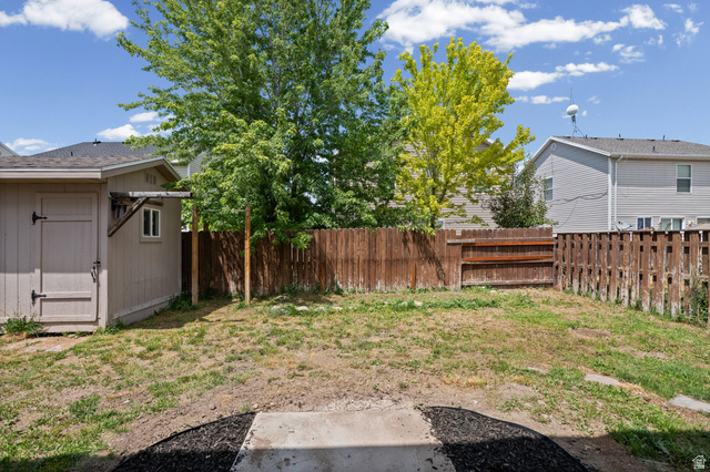 1346 Archmore Drive Springville, UT 84663 - Photo 23 of 32 Spacious backyard featuring a storage shed with a single window, a wood fence, and mature trees