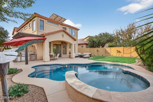 a view of a house with pool and chairs