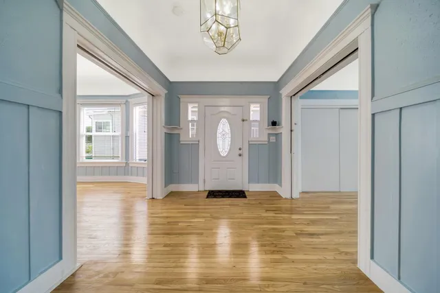a view of a hallway with wooden floor and cabinet