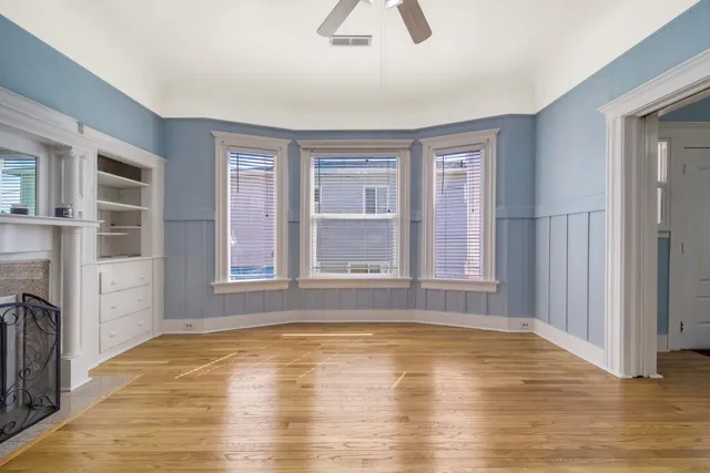 a view of an empty room with window and wooden floor