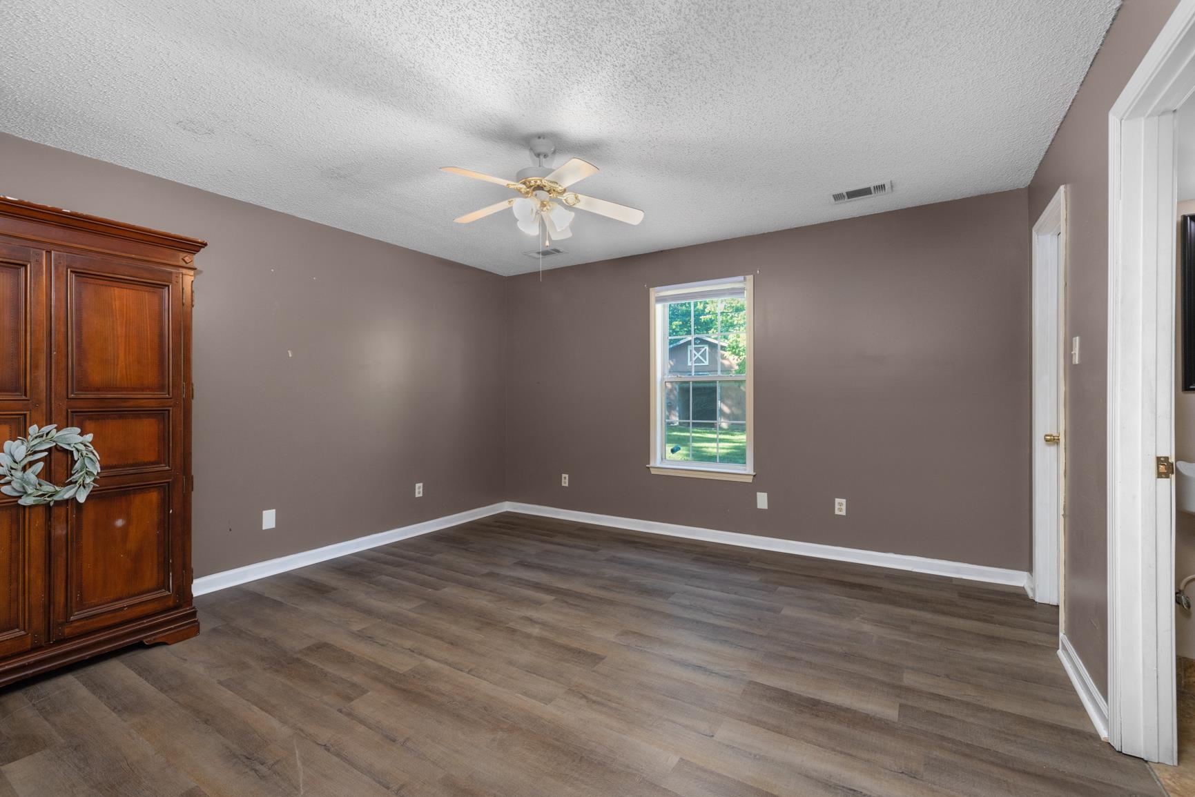 366 Adkins Road Burlison, TN 38015 - Photo 9 of 20 Spacious room featuring wood-finish flooring, neutral-toned walls, a ceiling fan, and a window providing natural illumination