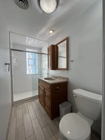 a bathroom with a granite countertop toilet sink and mirror
