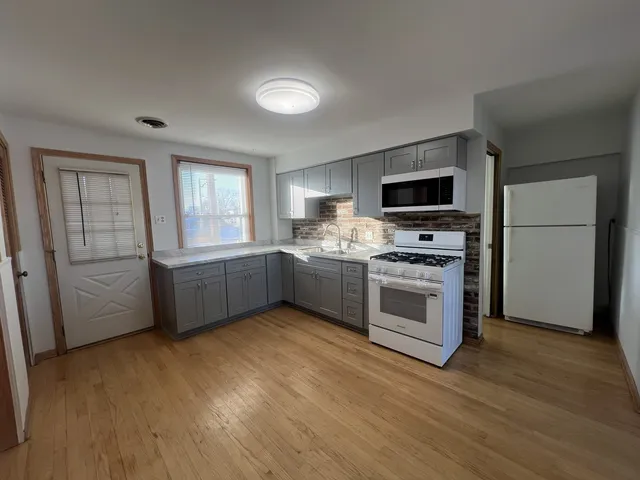 a kitchen with stainless steel appliances a stove a sink and a refrigerator