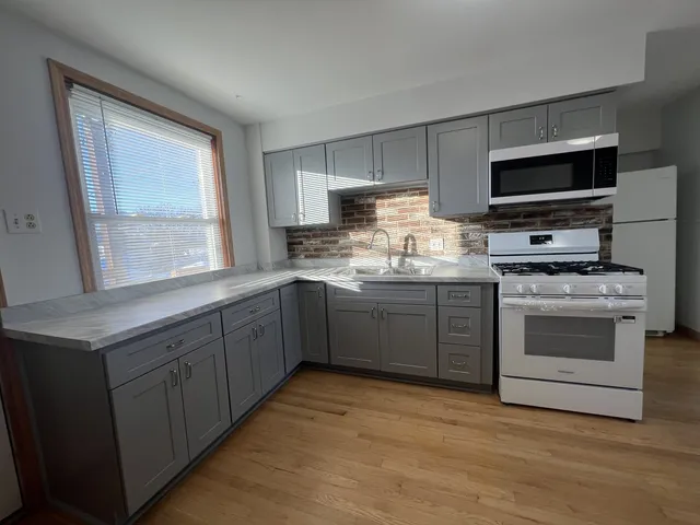 a kitchen with stainless steel appliances a stove sink microwave and cabinets