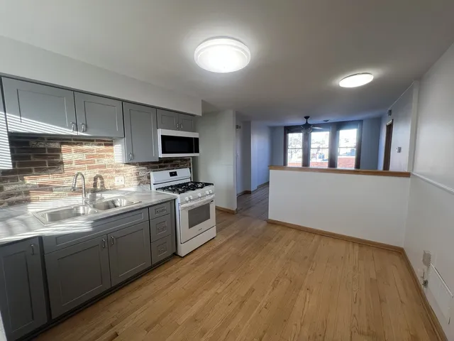 a kitchen with granite countertop a sink cabinets and stainless steel appliances