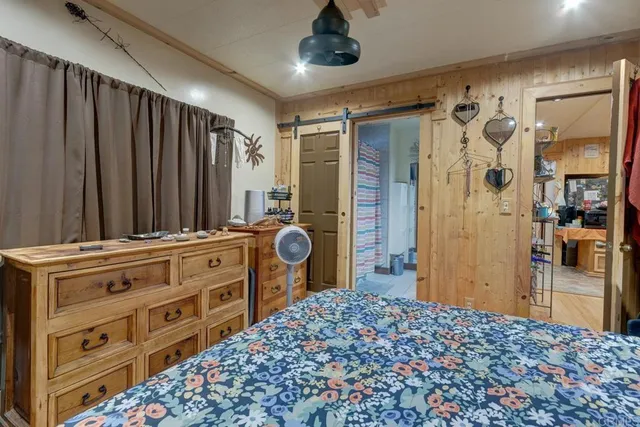 a bedroom with a dresser and a chandelier