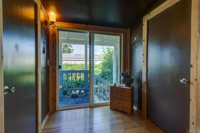 a view of a hallway with wooden floor and windows