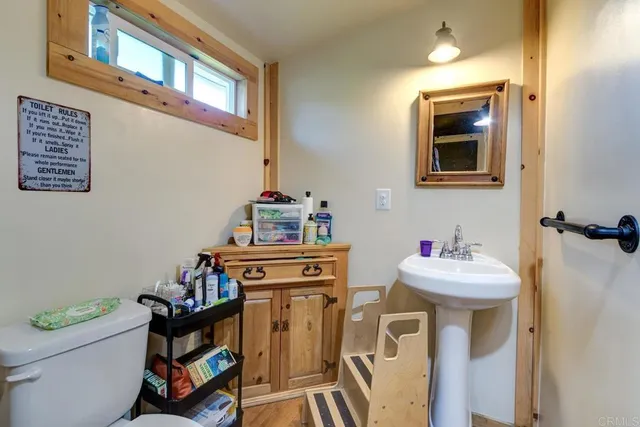 a bathroom with a sink mirror and toilet