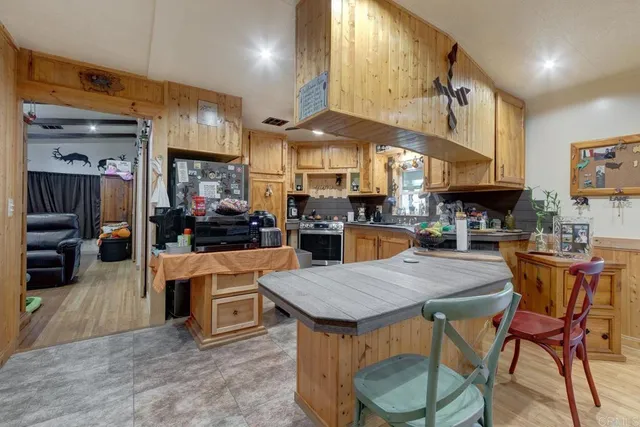a kitchen with stainless steel appliances granite countertop a kitchen island a table and chairs in it