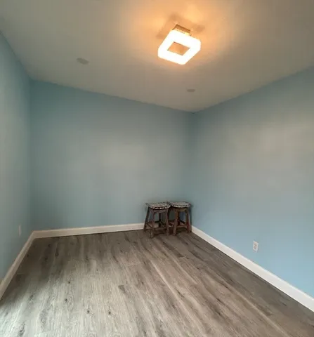 a view of a room with wooden floor and a window