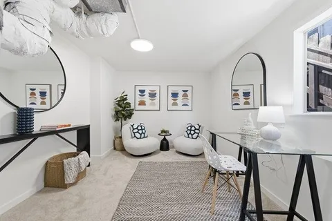 a view of a workspace room with furniture and mirror