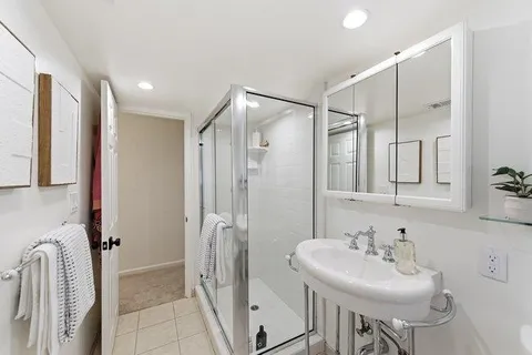 a bathroom with a sink a mirror and a shower
