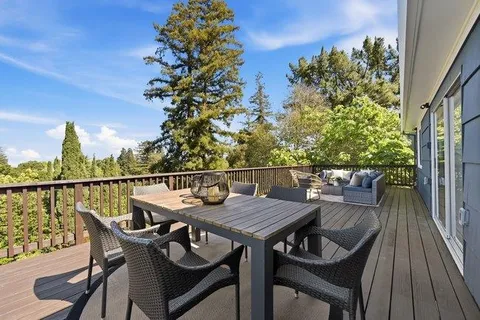 a balcony with wooden floor table and chairs