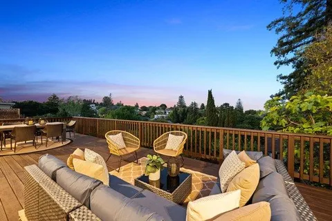 a balcony with wooden floor and outdoor seating