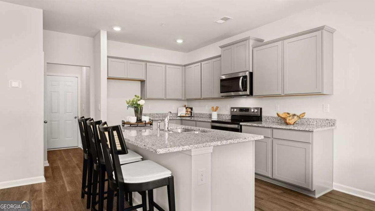 289 Sound Circle Stockbridge, GA 30281 - Photo 24 of 67 a kitchen with stainless steel appliances granite countertop a stove a sink a microwave and a refrigerator