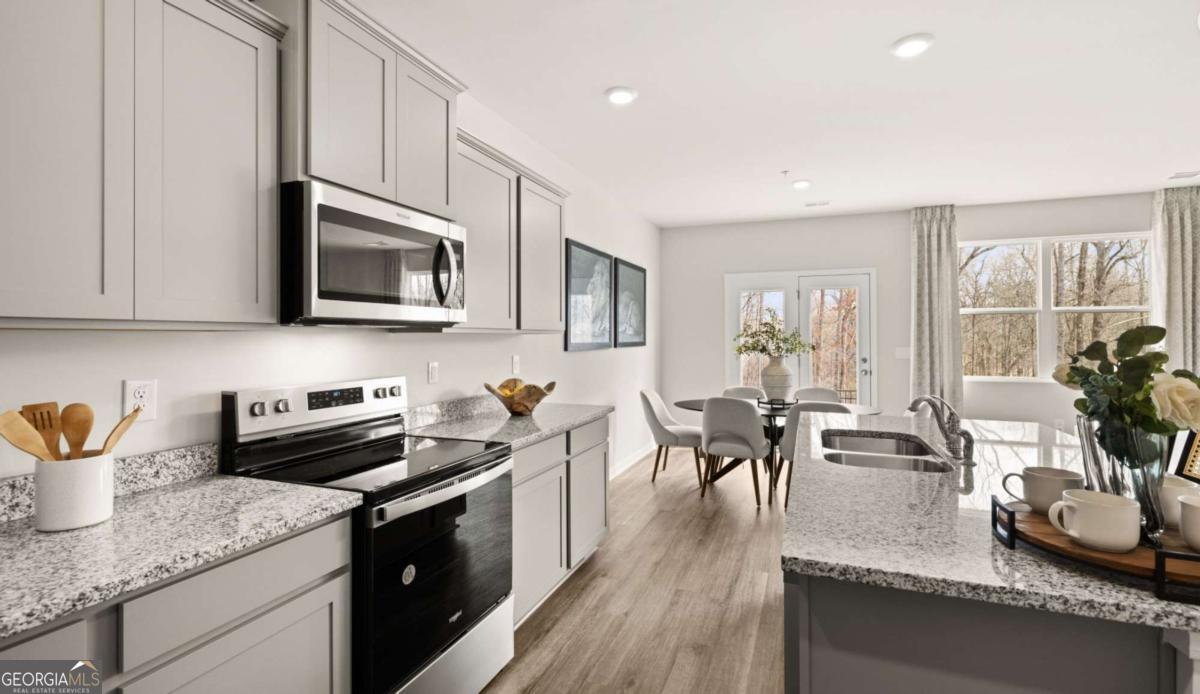 289 Sound Circle Stockbridge, GA 30281 - Photo 66 of 67 a kitchen with stainless steel appliances granite countertop a sink a stove top oven a counter space and cabinets