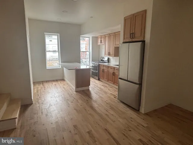 a kitchen with wooden floors and white stainless steel appliances