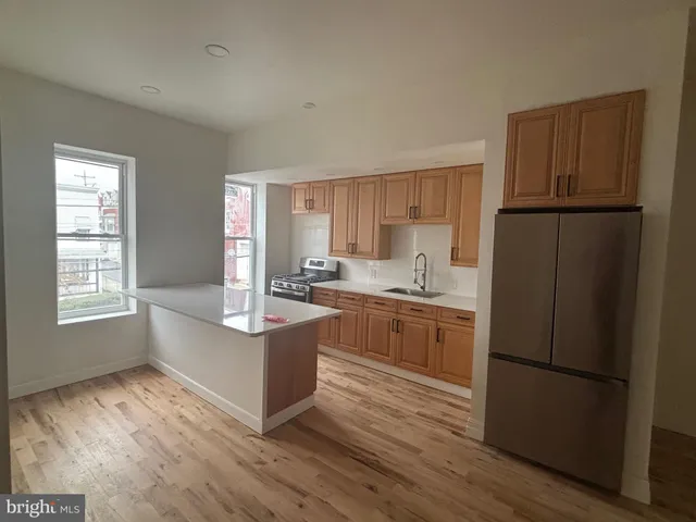 a kitchen with stainless steel appliances granite countertop a refrigerator a sink dishwasher a stove and a refrigerator