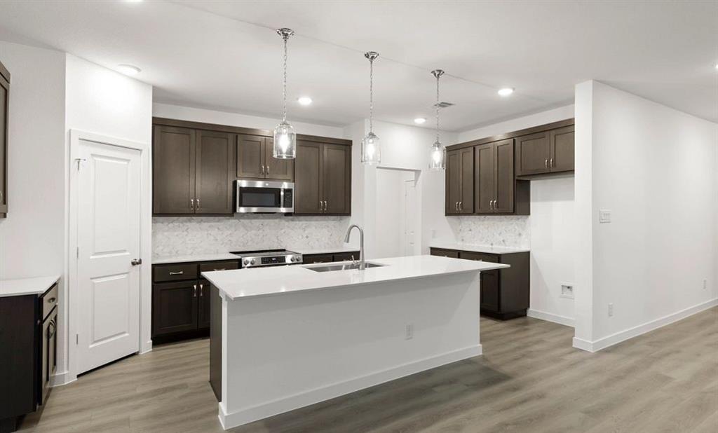 1005 Colgate Circle Princeton, TX 75407 - Photo 26 of 40 a kitchen with kitchen island a sink stainless steel appliances and cabinets