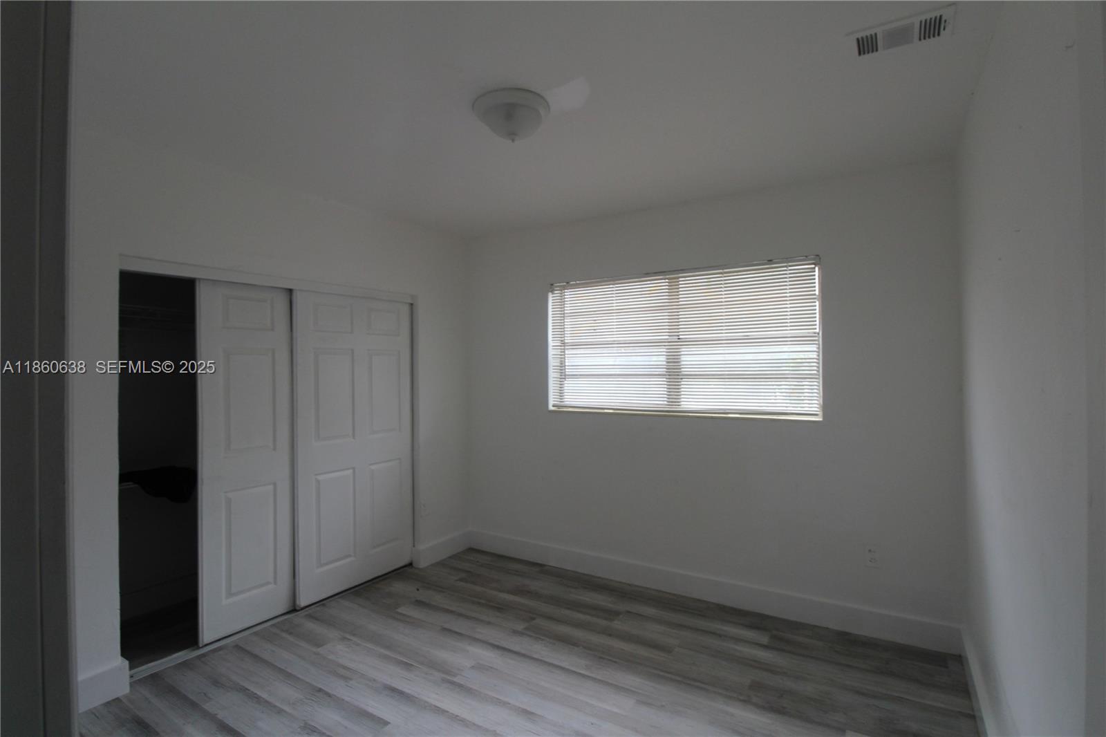 965 West 23rd Street Hialeah, FL 33010 - Photo 13 of 16 an empty room with wooden floor and windows