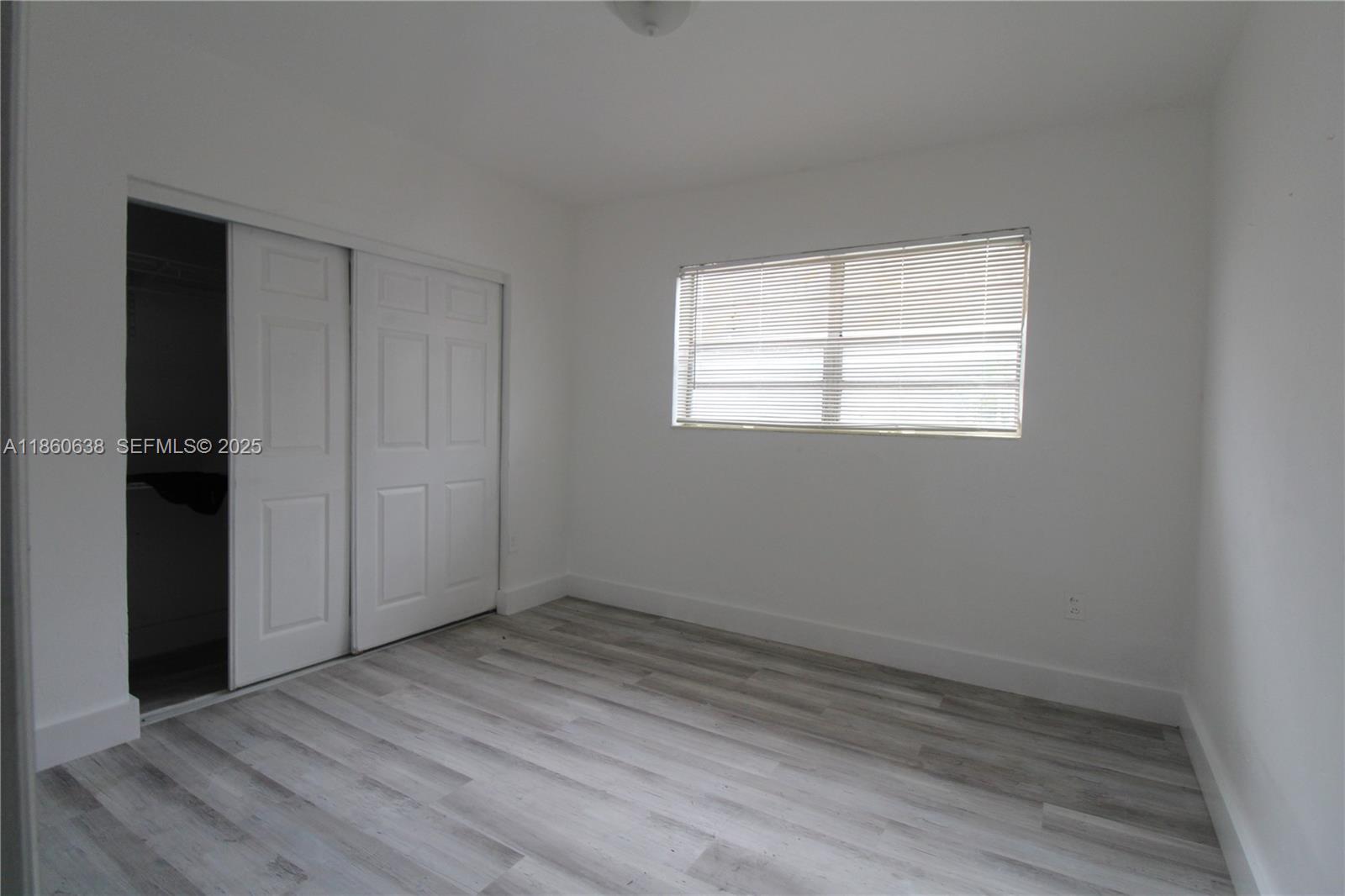 965 West 23rd Street Hialeah, FL 33010 - Photo 14 of 16 an empty room with wooden floor and windows