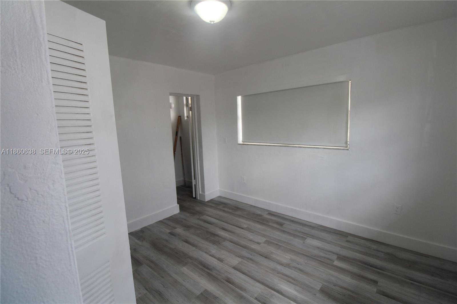 965 West 23rd Street Hialeah, FL 33010 - Photo 8 of 16 a view of an empty room with wooden floor and a window