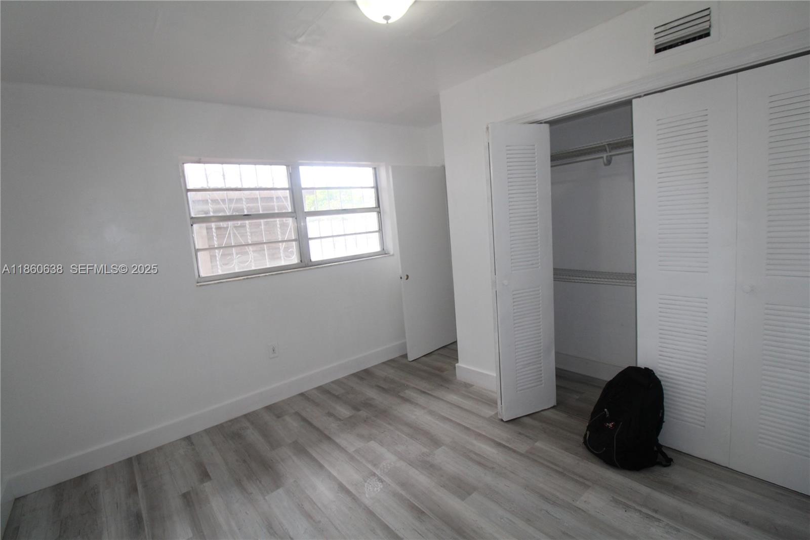 965 West 23rd Street Hialeah, FL 33010 - Photo 9 of 16 an empty room with wooden floor and windows