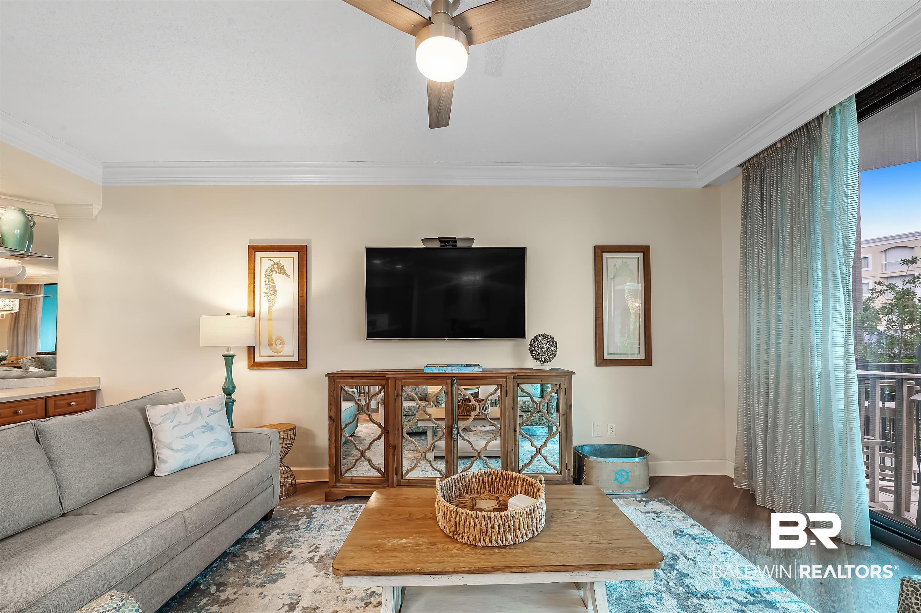 27582 Canal Road, Unit 2104 Orange Beach, AL 36561 - Photo 10 of 35 Living room with ceiling fan, ornamental molding, and dark hardwood / wood-style flooring, large flat screen TV
