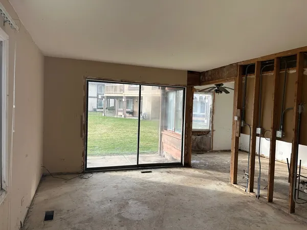 an empty room with sliding glass door and outdoor space
