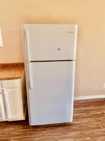 a white refrigerator freezer sitting next to a white wall