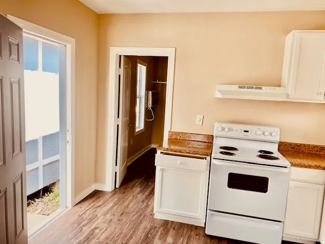 a kitchen with white cabinets and white appliances