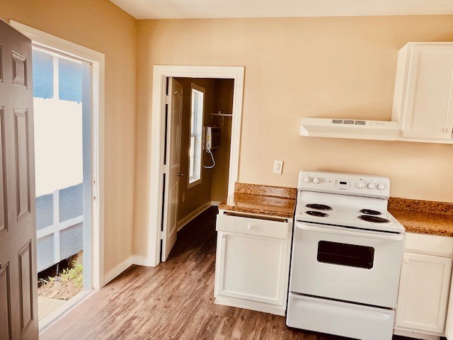 7409 Avenue L, Unit C Houston, TX 77011 - Photo 9 of 11 a kitchen with white cabinets and white appliances