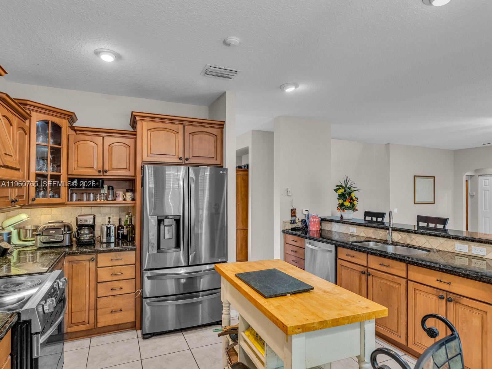 4209 Pinewood Lane Weston, FL 33331 - Photo 25 of 85 a kitchen with stainless steel appliances granite countertop a refrigerator and a stove top oven