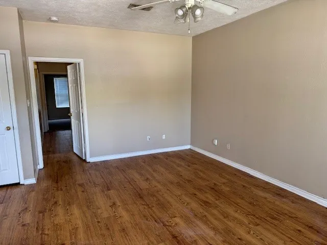 a view of an empty room with wooden floor