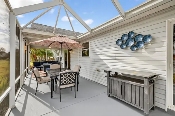a view of a patio with lawn chairs next to a yard