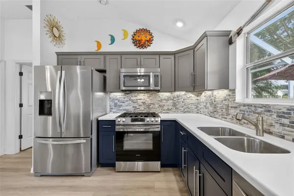 a kitchen with stainless steel appliances granite countertop a sink stove and refrigerator