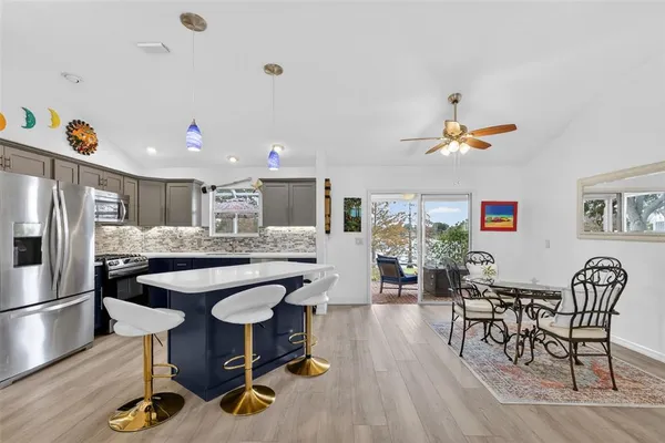 a kitchen with stainless steel appliances a dining table chairs and stove top oven