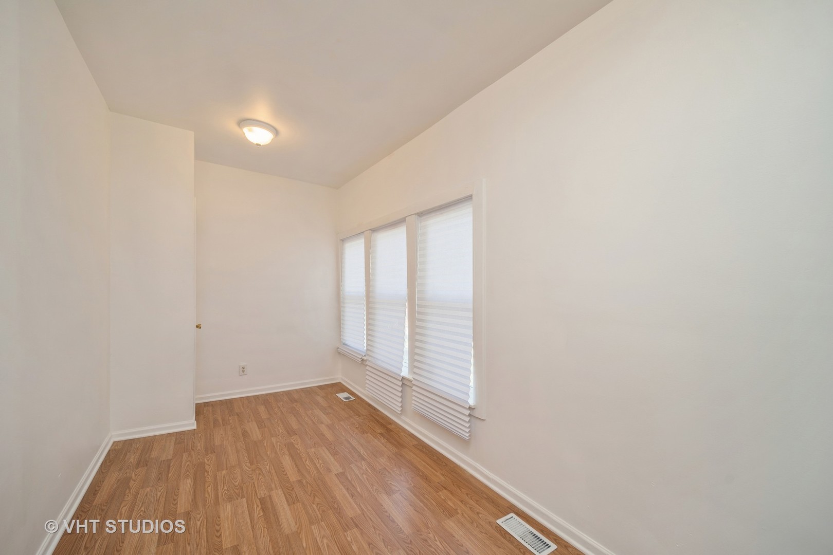 552 East 91st Place Chicago, IL 60619 - Photo 13 of 17 a view of an empty room with wooden floor and a window