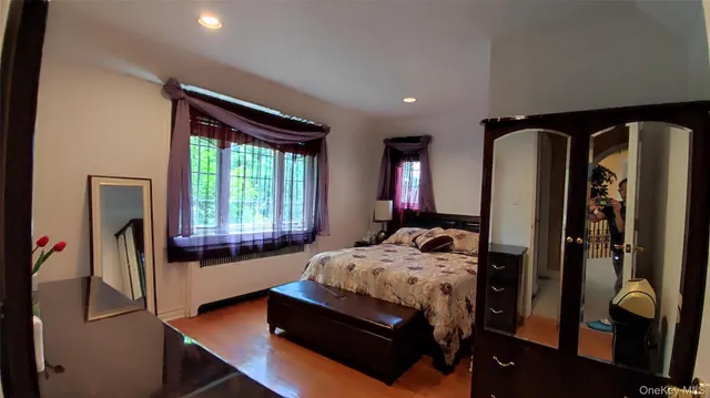 a bedroom with a bed and dresser with mirror