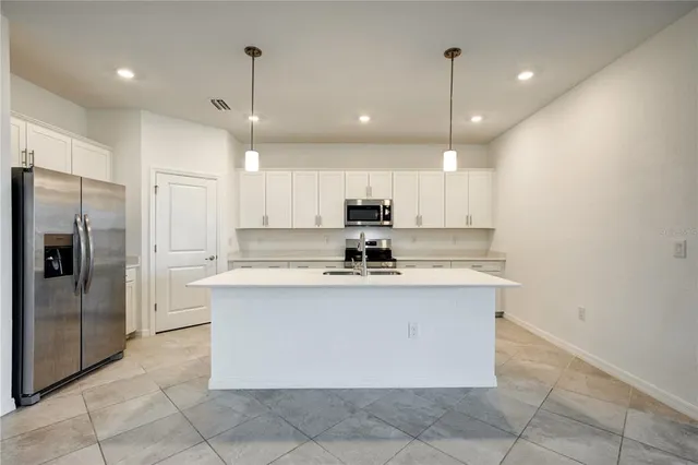 a kitchen with kitchen island a sink stainless steel appliances and cabinets