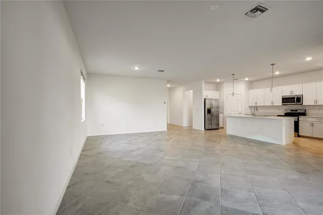 a view of kitchen with kitchen island white cabinets and refrigerator