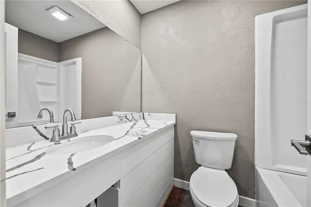 a bathroom with a toilet sink and mirror